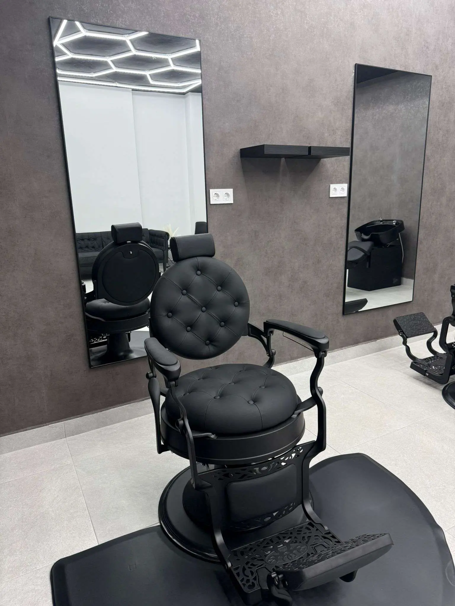 Sala de espera cómoda con sofá negro en barbería Elegance Barber Ayamonte Huelva